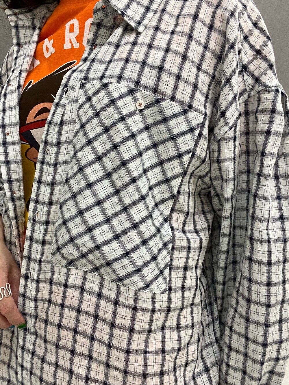 オレンジ系のTシャツ/カットソー、ホワイト系のシャツ/ブラウス、ブルー系のデニムパンツを着用したレディースの春コーディネートの7枚目の写真