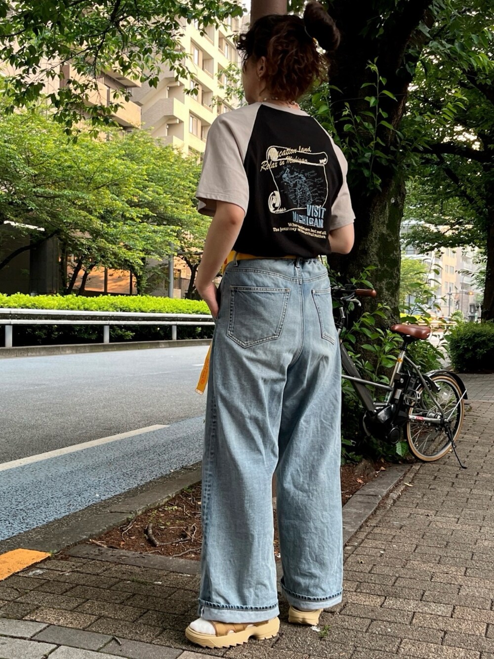 ブラック系のTシャツ/カットソー、ブルー系のデニムパンツ、イエロー系のベルトを着用したレディースの夏コーディネートの2枚目の写真