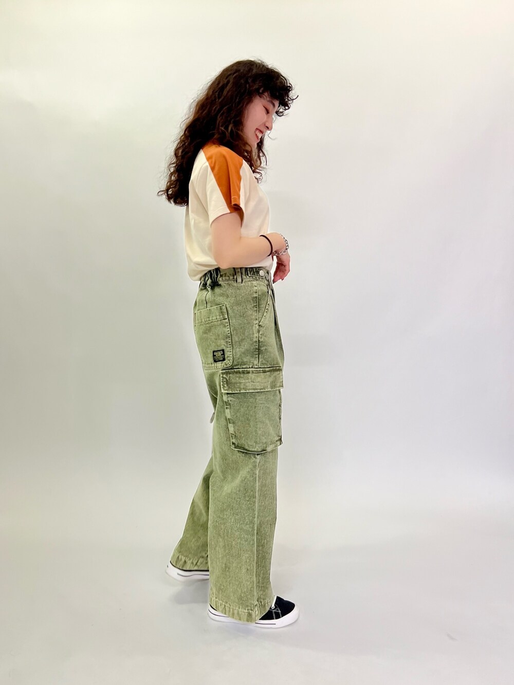 ホワイト系のTシャツ/カットソー、グリーン系のデニムパンツを着用したレディースの春コーディネートの6枚目の写真