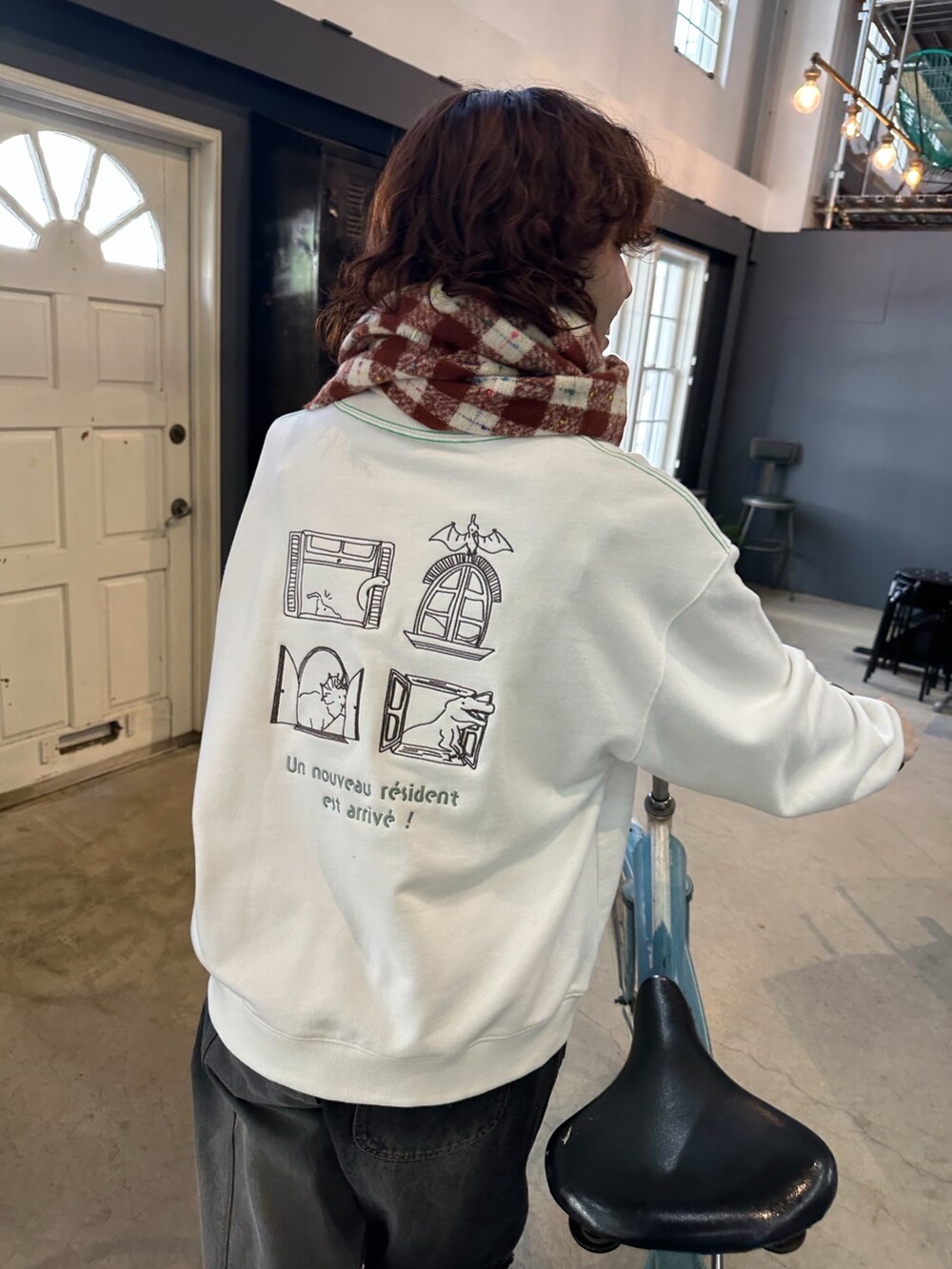 ホワイト系のその他トップス、ブラック系のデニムパンツ、レッド系のマフラーを着用したレディースの秋コーディネートの2枚目の写真