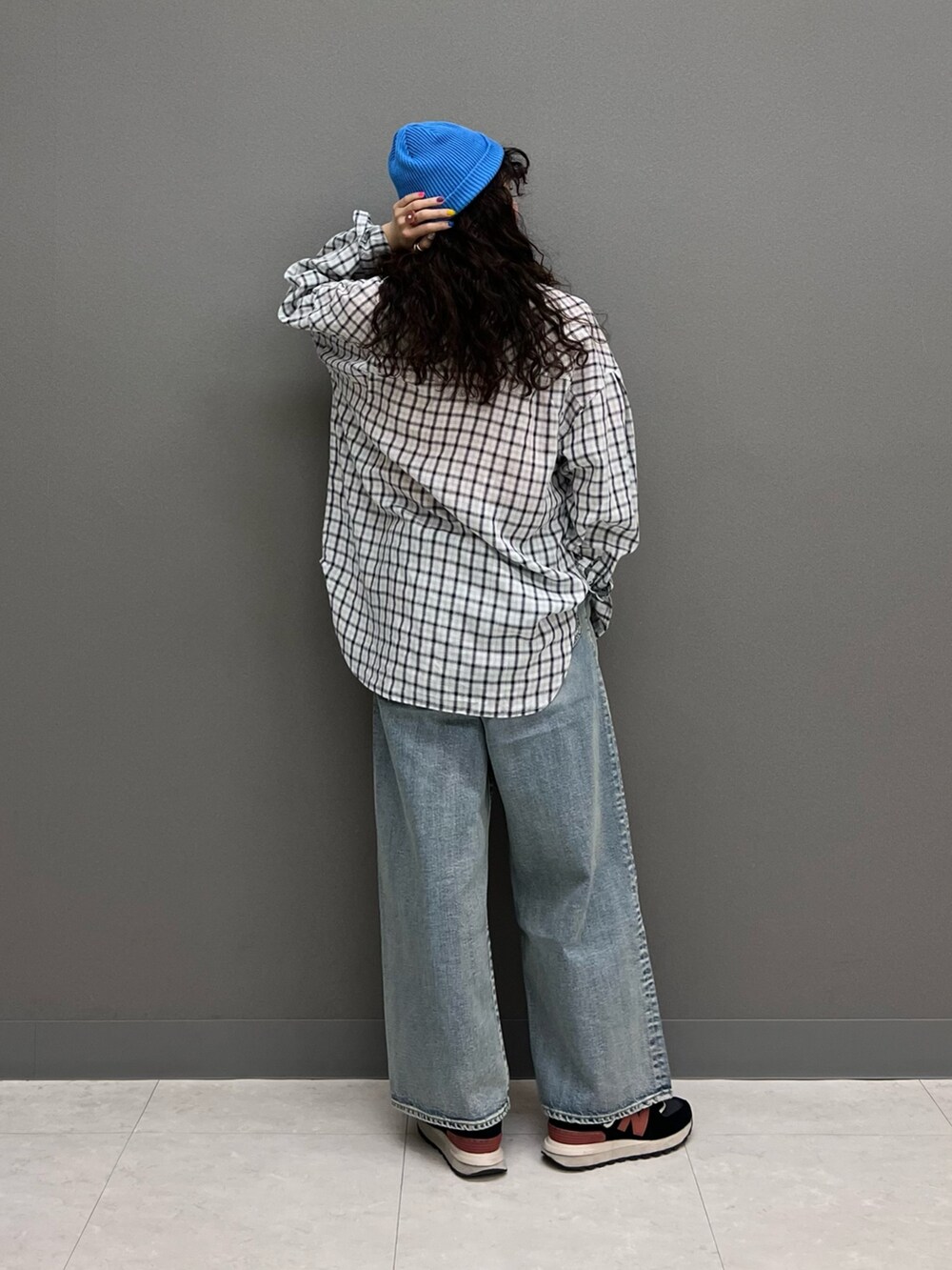 オレンジ系のTシャツ/カットソー、ホワイト系のシャツ/ブラウス、ブルー系のデニムパンツを着用したレディースの春コーディネートの2枚目の写真