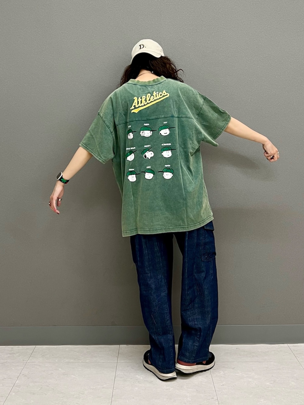 グリーン系のTシャツ/カットソー、ブルー系のデニムパンツ、ピンク系のベルトを着用したレディースの春コーディネートの4枚目の写真