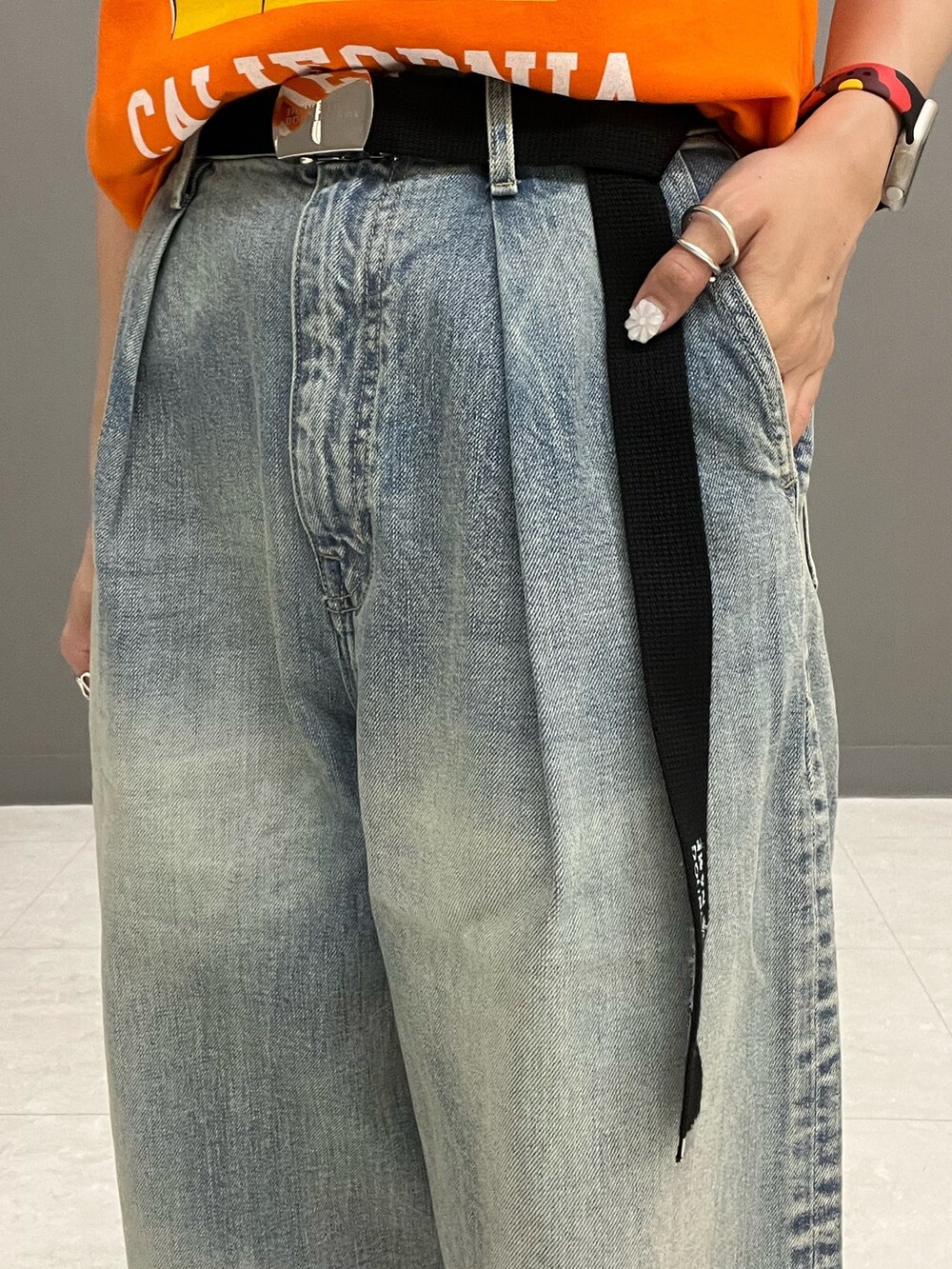 オレンジ系のTシャツ/カットソー、ホワイト系のシャツ/ブラウス、ブルー系のデニムパンツを着用したレディースの春コーディネートの9枚目の写真