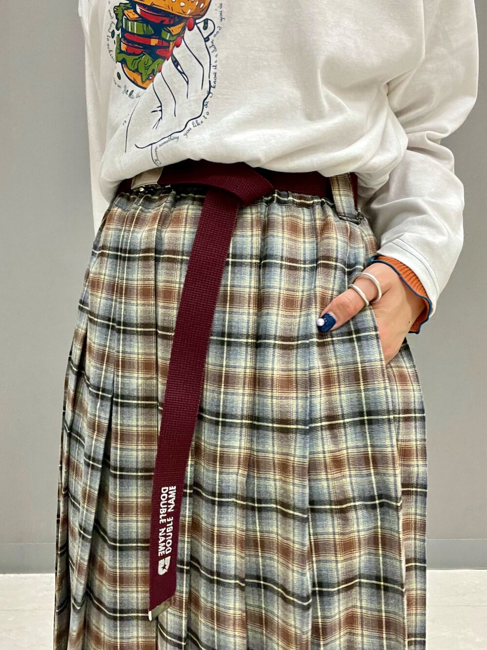 ホワイト系のTシャツ/カットソー、グレー系のスカート、オレンジ系のTシャツ/カットソーを着用したレディースの夏コーディネートの7枚目の写真