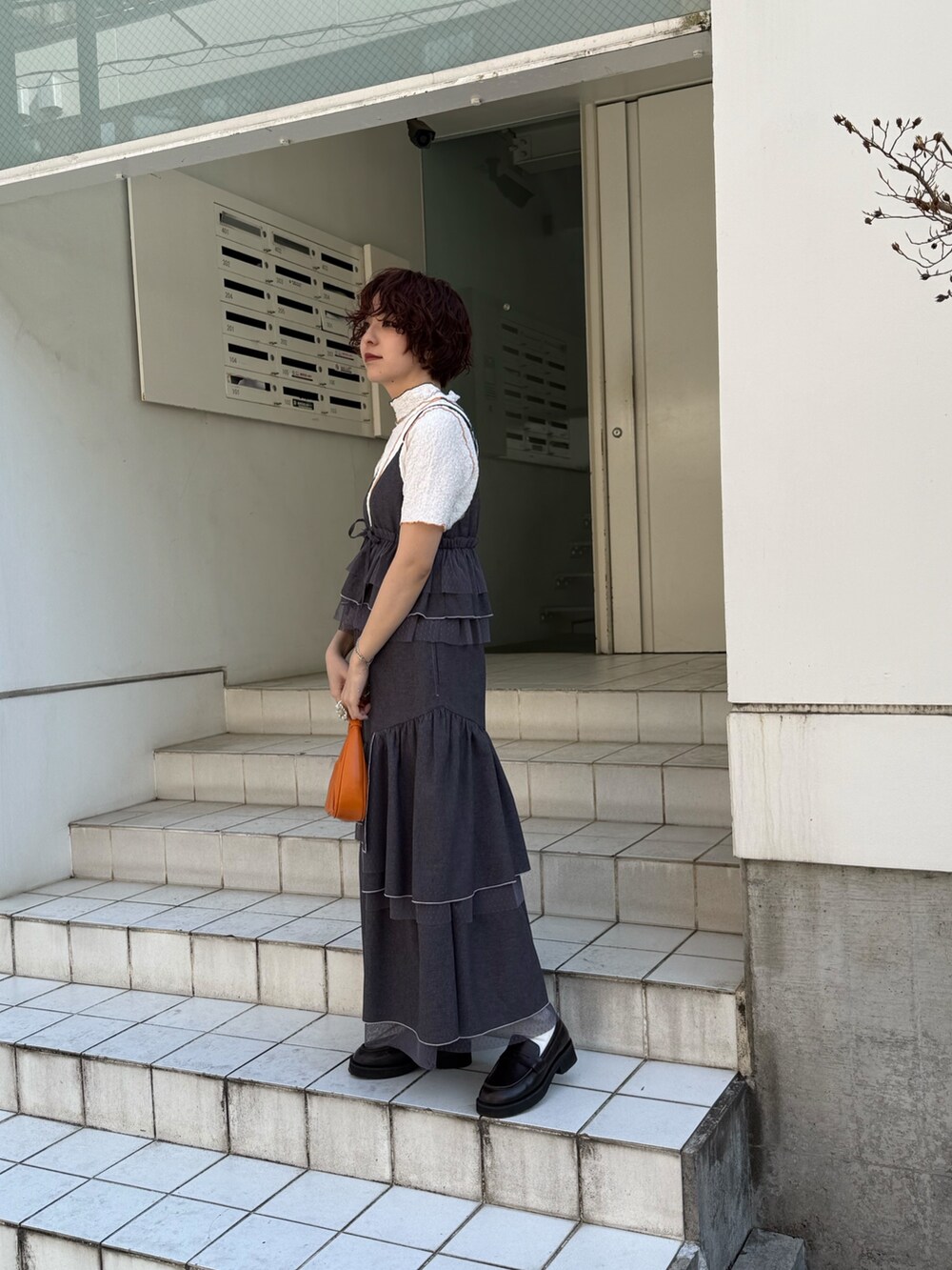 グレー系のスカート、グレー系のキャミソール、ホワイト系のTシャツ/カットソーを着用したレディースの春コーディネートの3枚目の写真