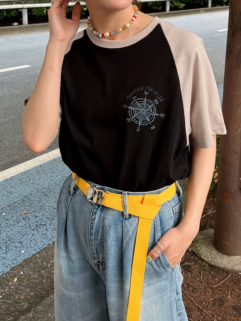 ブラック系のTシャツ/カットソー、ブルー系のデニムパンツ、イエロー系のベルトを着用したレディースの夏コーディネートの3枚目の写真