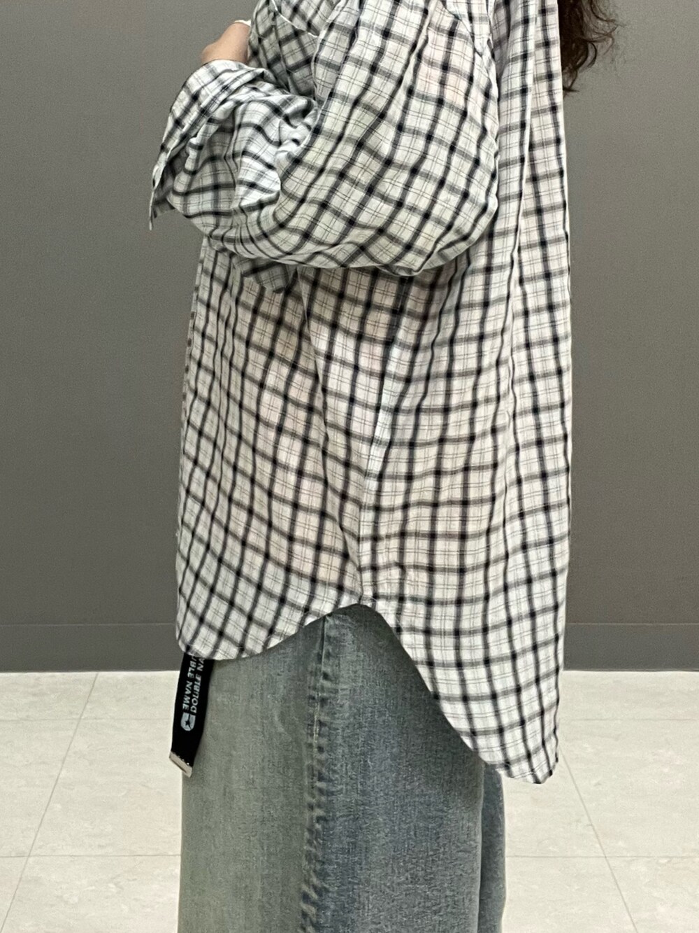 オレンジ系のTシャツ/カットソー、ホワイト系のシャツ/ブラウス、ブルー系のデニムパンツを着用したレディースの春コーディネートの8枚目の写真