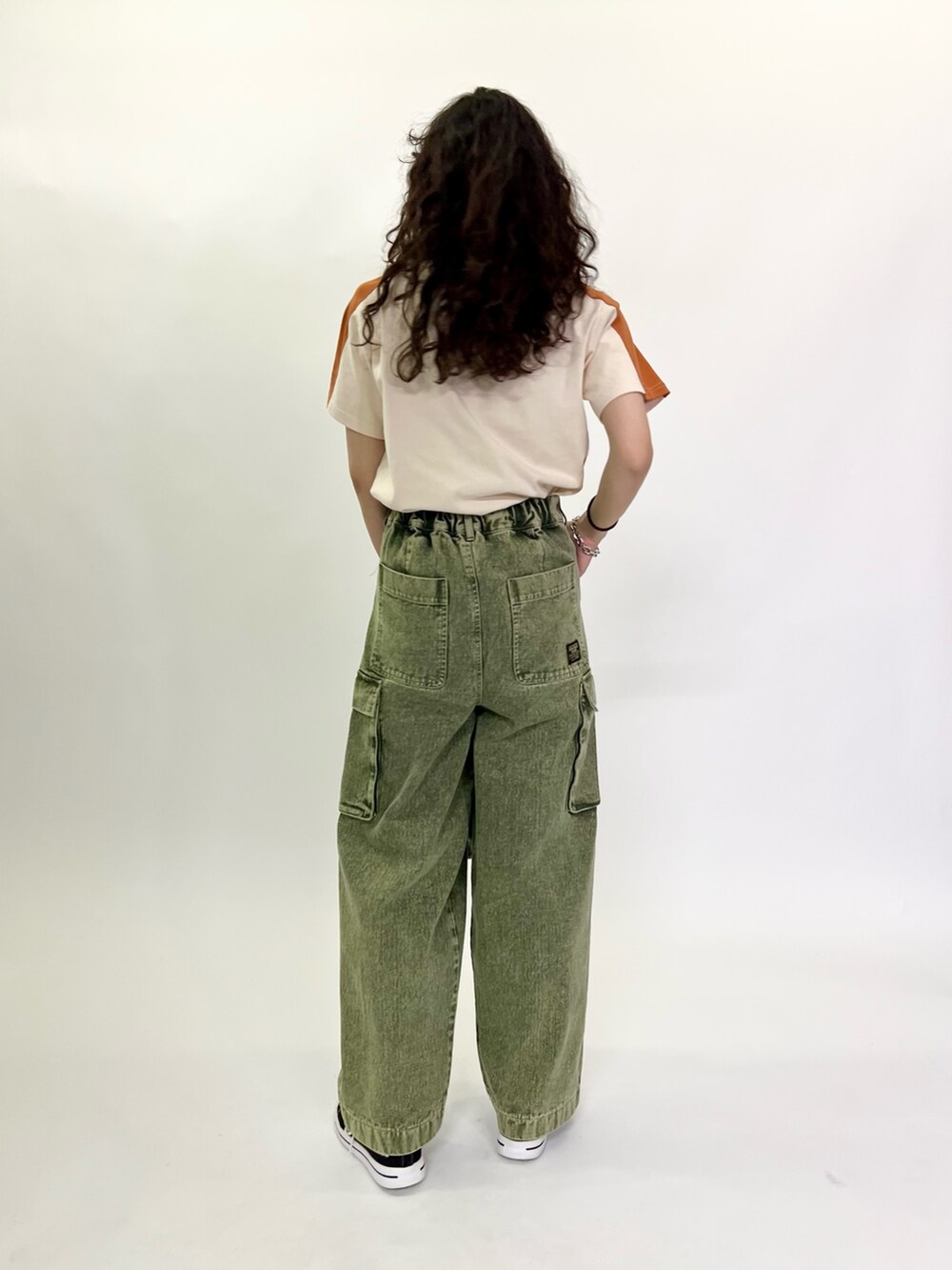 ホワイト系のTシャツ/カットソー、グリーン系のデニムパンツを着用したレディースの春コーディネートの4枚目の写真