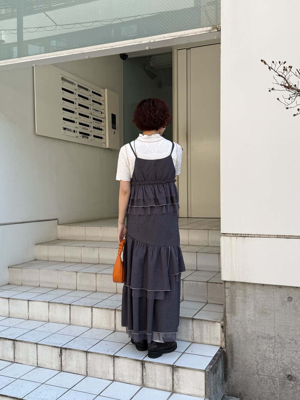 グレー系のスカート、グレー系のキャミソール、ホワイト系のTシャツ/カットソーを着用したレディースの春コーディネートの2枚目の写真