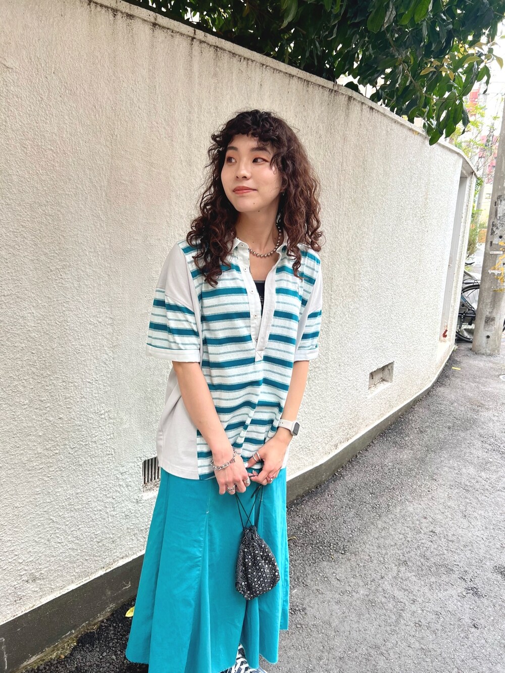 ホワイト系のTシャツ/カットソー、ブルー系のスカート、ブラック系のタンクトップを着用したレディースの春コーディネートの4枚目の写真