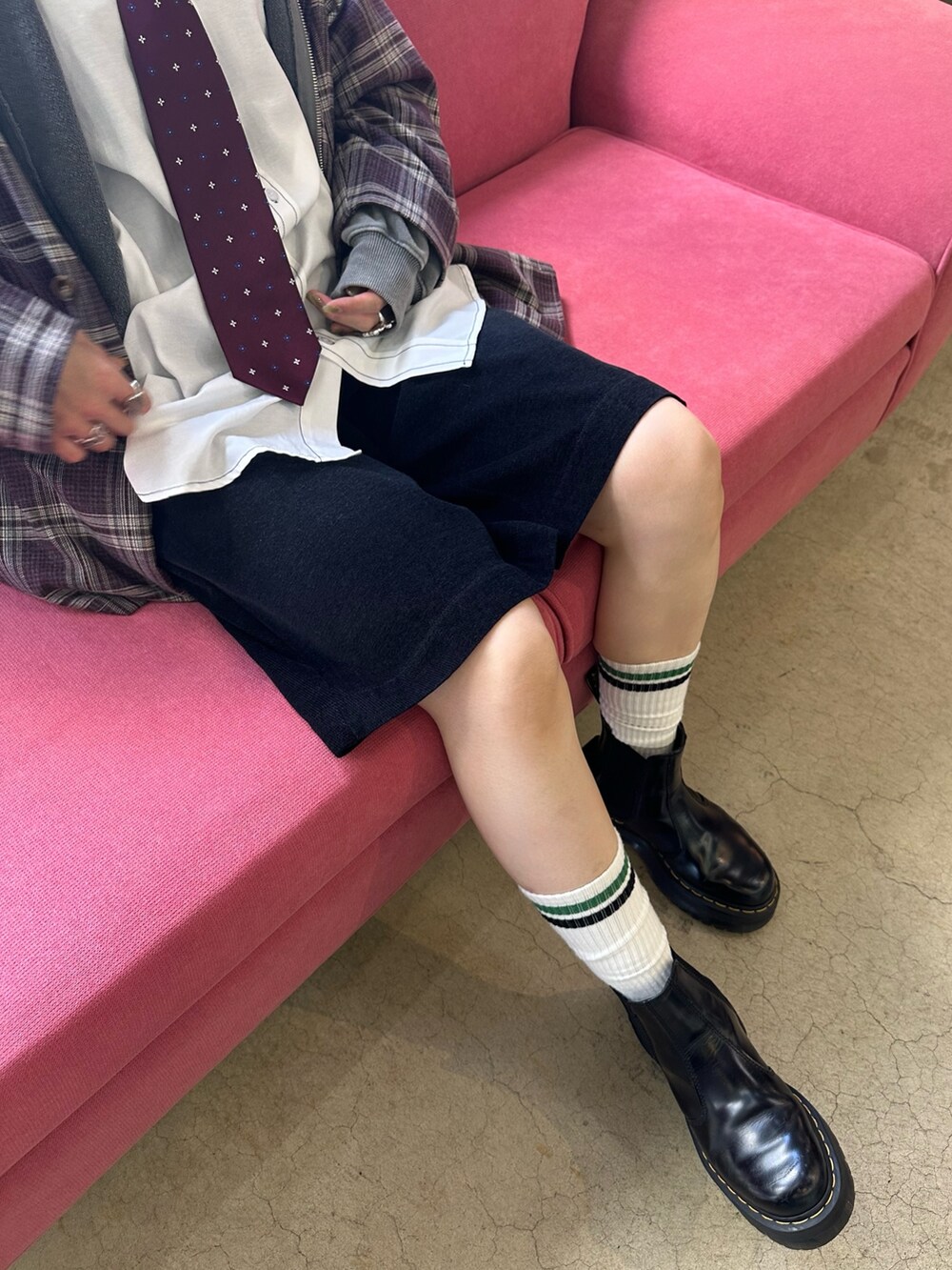 レッド系のネクタイ、グレー系のパーカー、ブルー系のその他パンツを着用したレディースの秋コーディネートの5枚目の写真