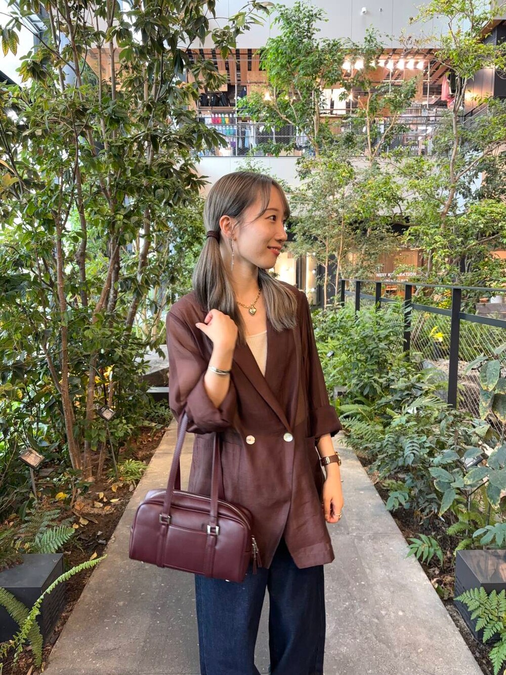 ホワイト系のタンクトップ、レッド系のボストンバッグ、ブラウン系のテーラードジャケットを着用したレディースの秋コーディネートの3枚目の写真