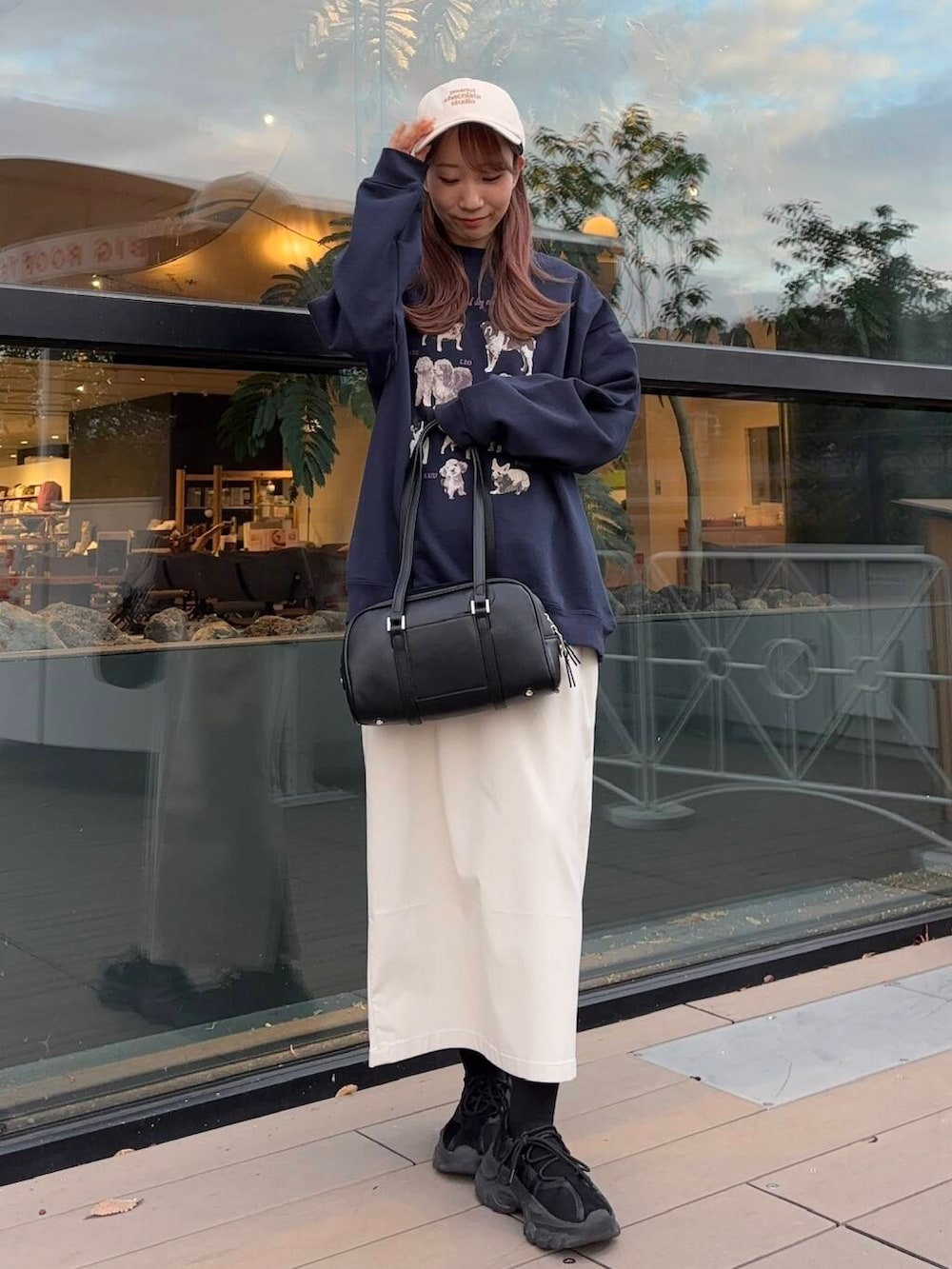 ブラック系のボストンバッグ、ブラック系のスニーカー、ブルー系のスウェットを着用したレディースの冬コーディネートの2枚目の写真