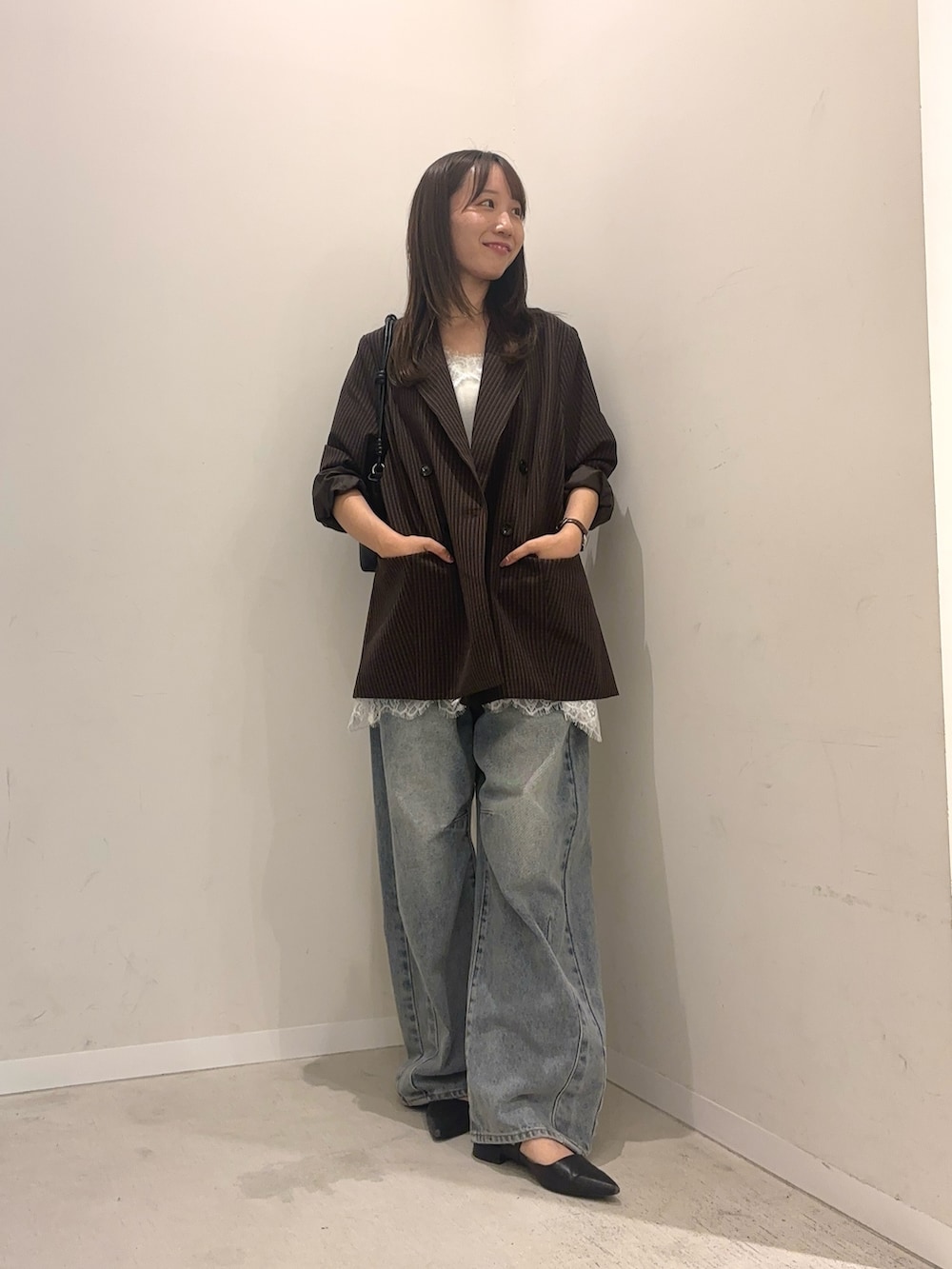 ブラウン系のその他アウター、ホワイト系のキャミソール、ブルー系のデニムパンツを着用したレディースの秋コーディネートの2枚目の写真