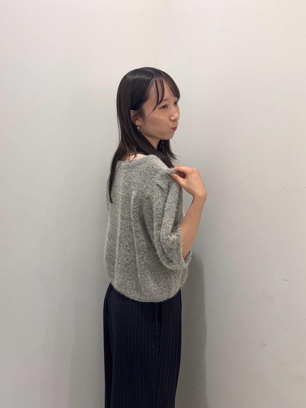 グレー系のニット/セーター、グレー系のその他パンツ、ブラック系のスリッポンを着用したレディースの夏コーディネートの3枚目の写真