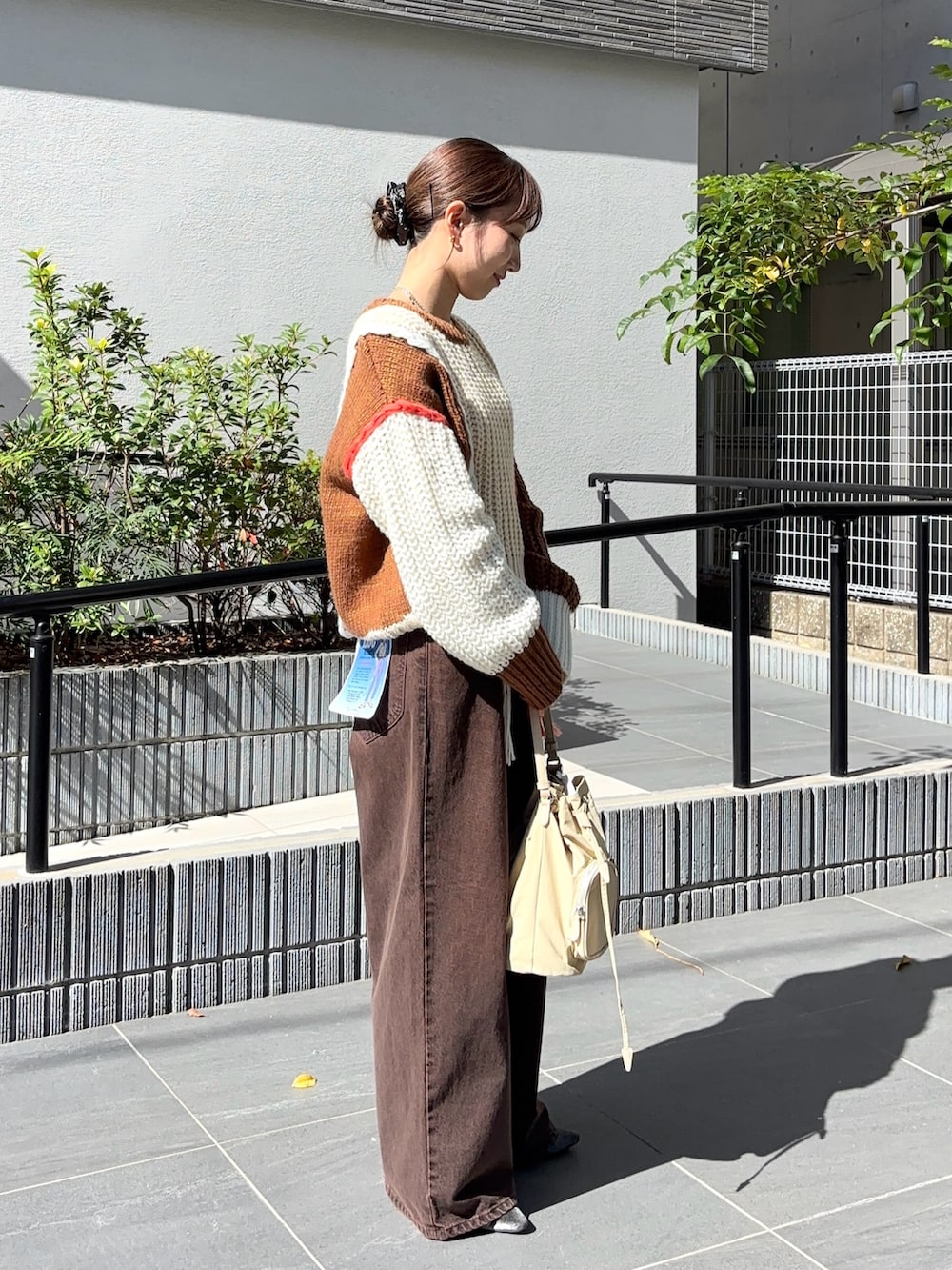 ブラウン系のニット/セーター、ブラウン系のデニムパンツ、グレー系のパンプスを着用したレディースの秋コーディネートの2枚目の写真