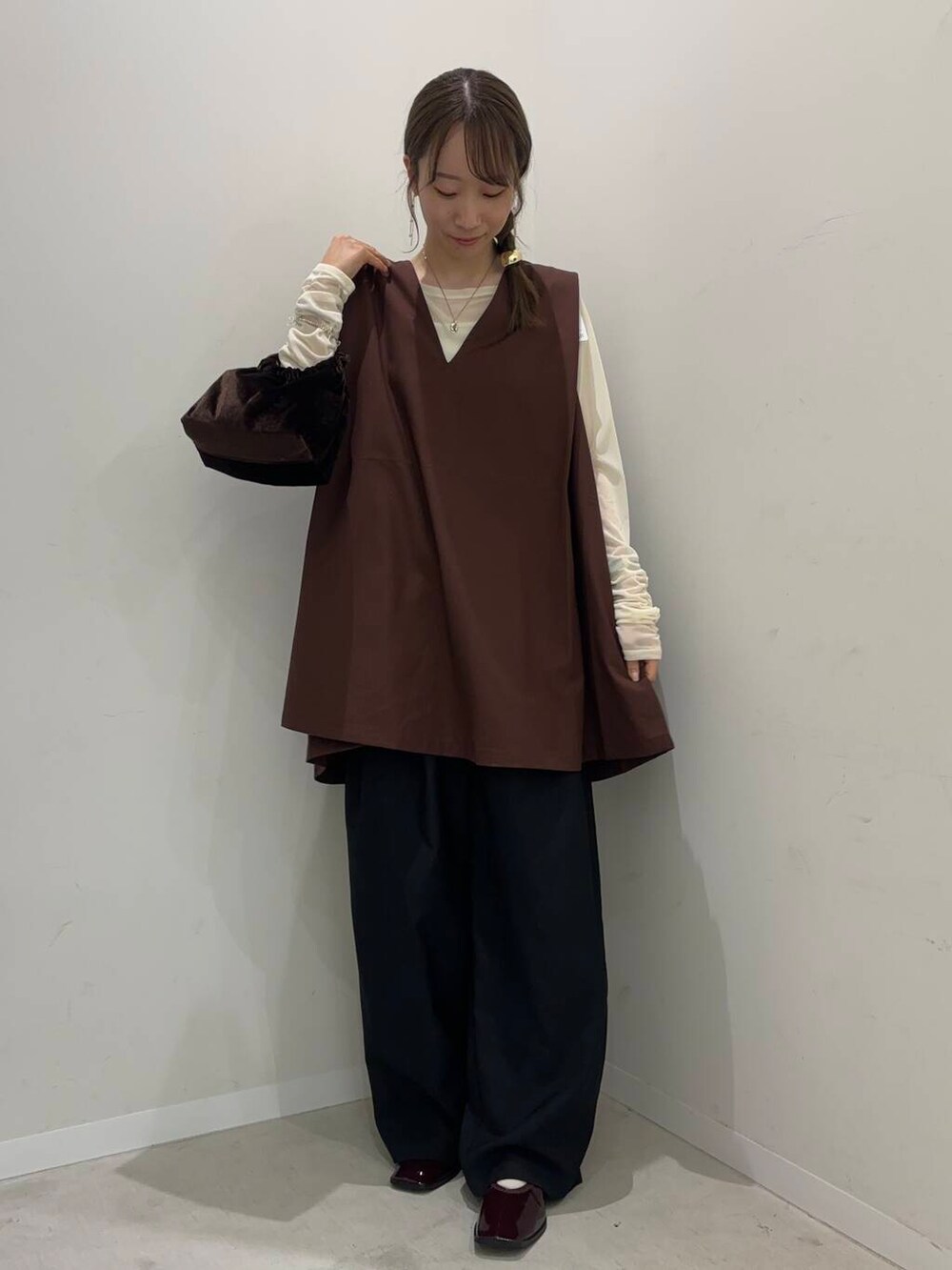 ブラック系のその他パンツ、レッド系のバレエシューズ、ブラウン系のハンドバッグを着用したレディースの夏コーディネートの3枚目の写真