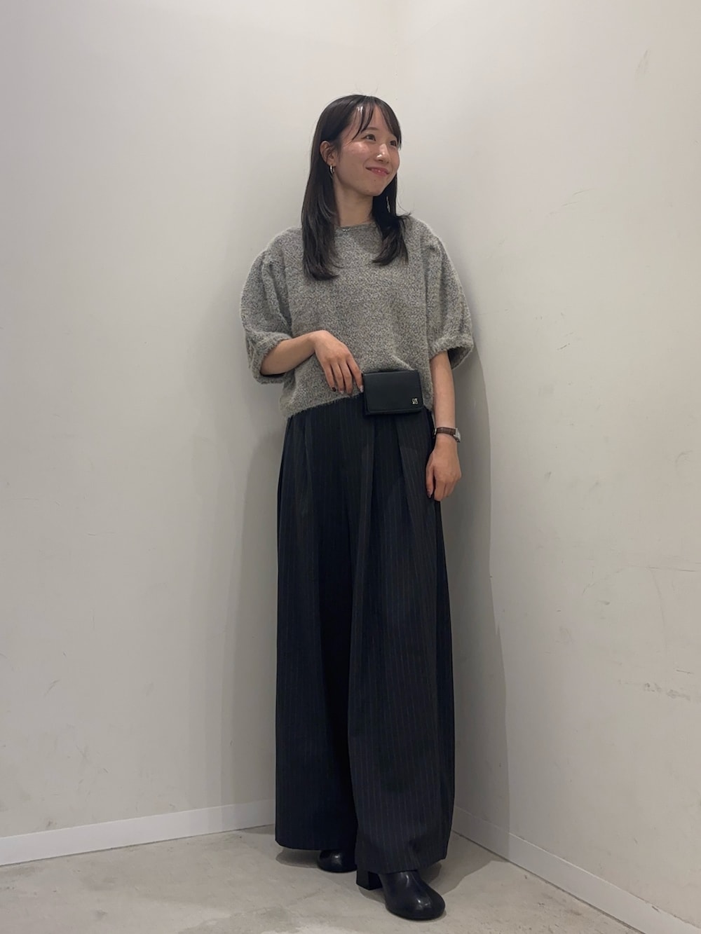 グレー系のニット/セーター、グレー系のその他パンツ、ブラック系のスリッポンを着用したレディースの夏コーディネートの2枚目の写真