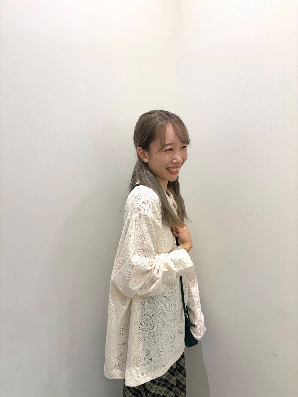 グリーン系のショルダーバッグ、ブラウン系のブーツ、グリーン系のスカートを着用したレディースの秋コーディネートの2枚目の写真