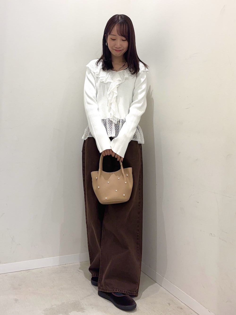 ホワイト系のニット/セーター、ブラウン系のデニムパンツ、ブラウン系のその他シューズを着用したレディースの秋コーディネートの2枚目の写真