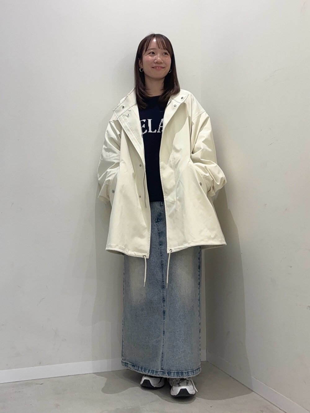 ブルー系のニット/セーター、ホワイト系のミリタリージャケット、ブルー系のスカートを着用したレディースの冬コーディネートの2枚目の写真