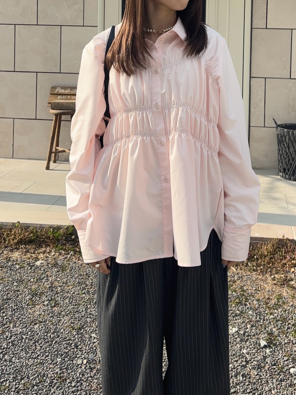 ピンク系のシャツ/ブラウス、グレー系のその他パンツを着用したレディースの春コーディネートの2枚目の写真