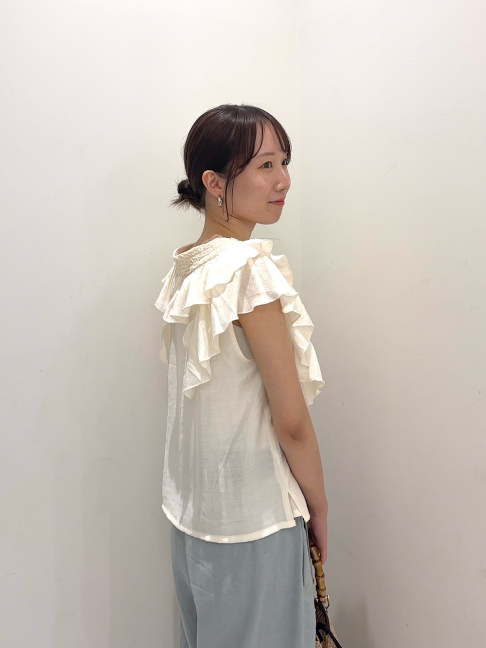 ホワイト系のシャツ/ブラウス、ブルー系のデニムパンツ、ブラック系のショルダーバッグを着用したレディースの春コーディネートの3枚目の写真