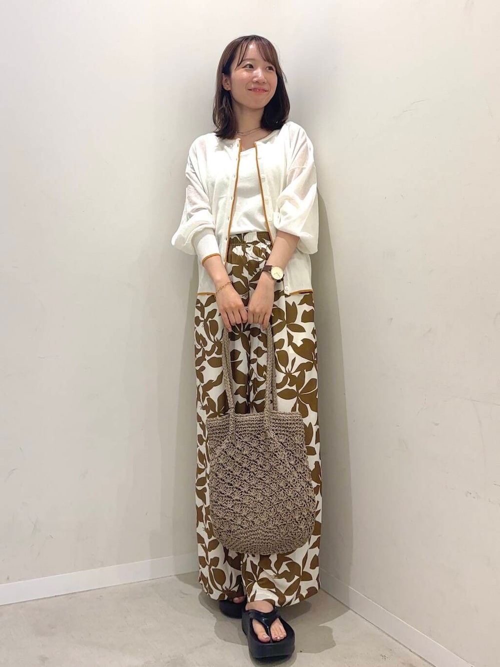 ブラック系のサンダル、グレー系のトートバッグ、ホワイト系のタンクトップを着用したレディースの夏コーディネートの2枚目の写真