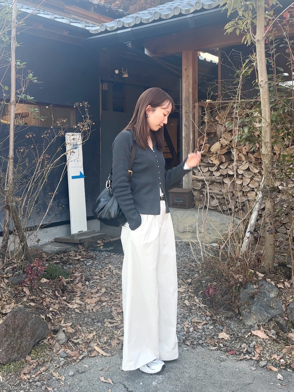 グレー系のカーディガン/ボレロ、ホワイト系のチノパンツ、シルバー系のネックレスを着用したレディースの冬コーディネートの2枚目の写真