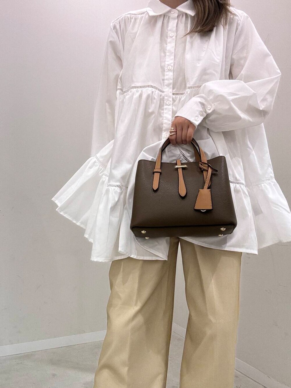 ベージュ系のサンダル、ベージュ系のその他パンツ、ブラウン系のハンドバッグを着用したレディースの夏コーディネートの2枚目の写真