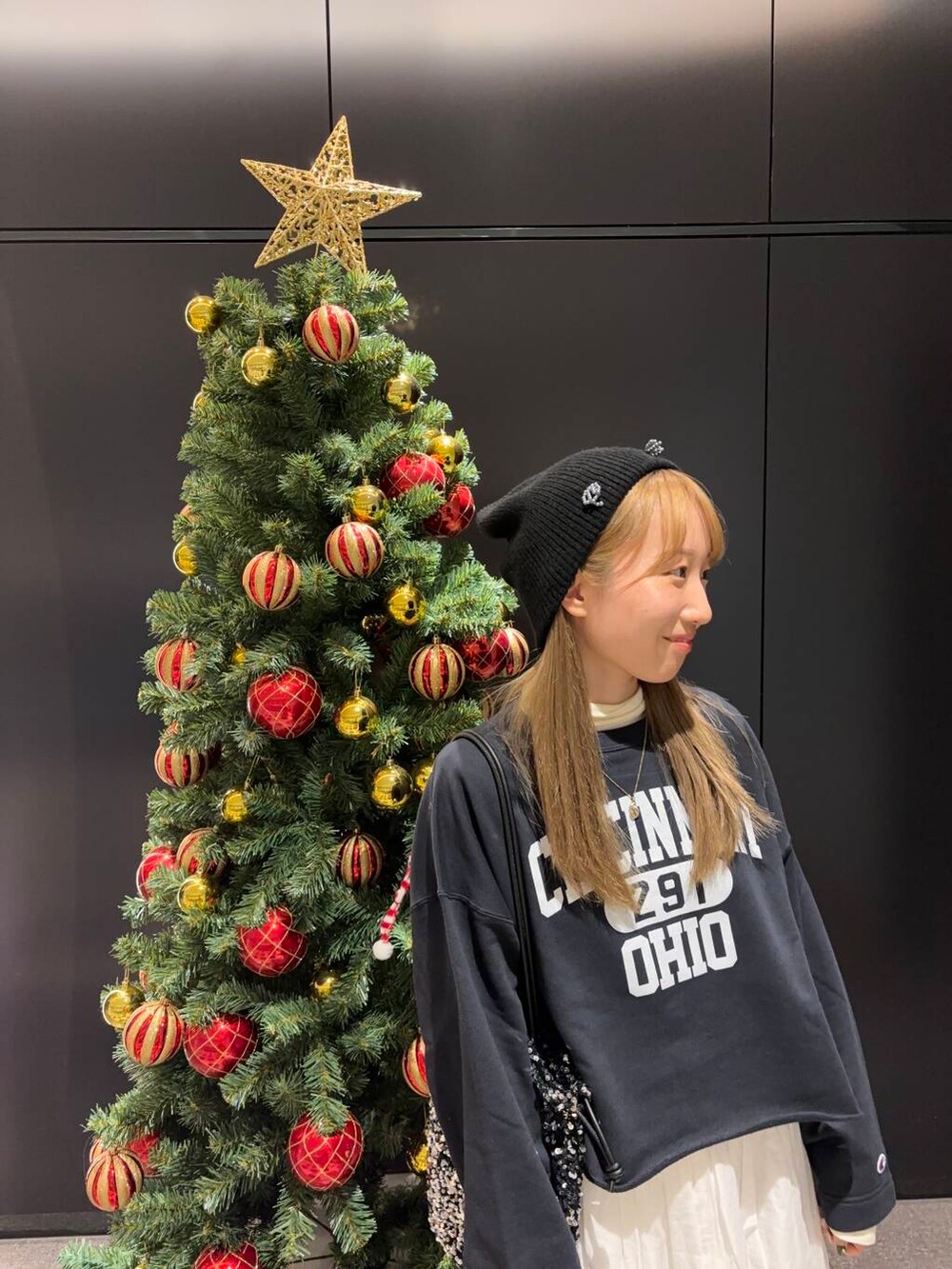 シルバー系のトートバッグ、ホワイト系のTシャツ/カットソー、ホワイト系のスカートを着用したレディースの冬コーディネートの2枚目の写真