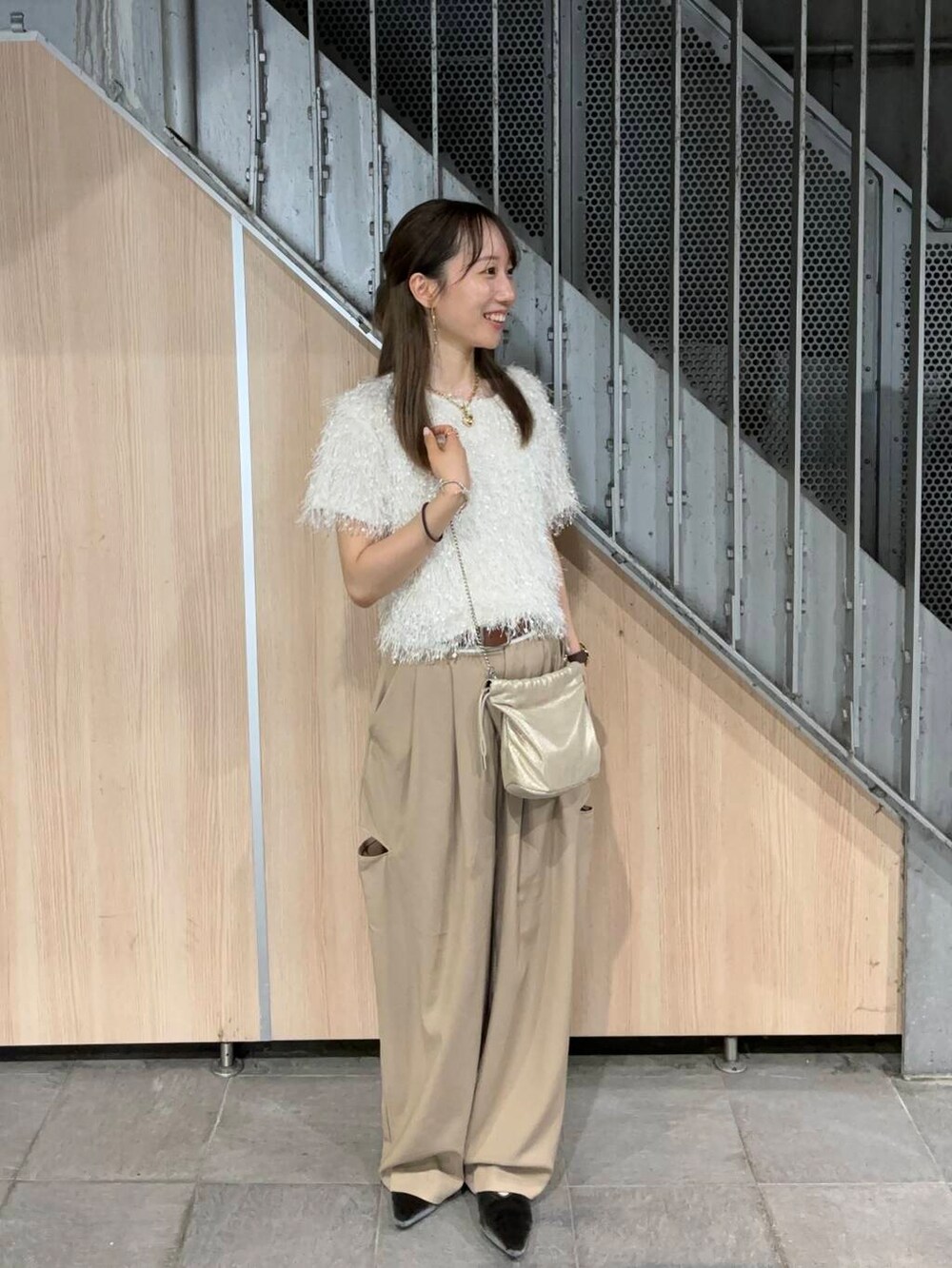 ホワイト系のその他トップス、ベージュ系のその他パンツ、ゴールド系のイヤリングを着用したレディースの夏コーディネートの2枚目の写真