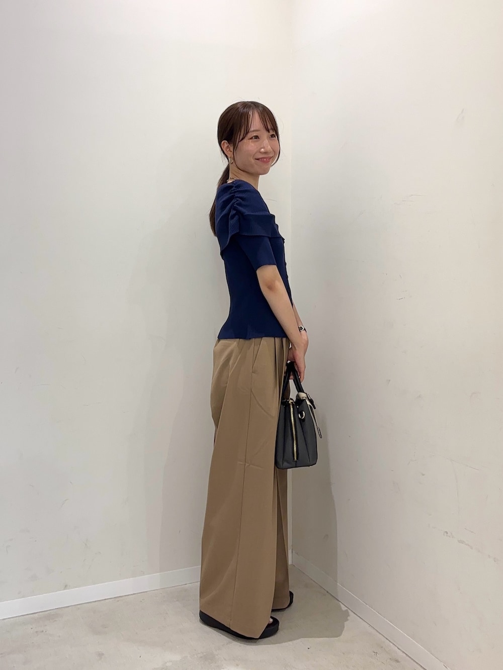 ブルー系のニット/セーター、ベージュ系のその他パンツ、ブラック系のサンダルを着用したレディースの春コーディネートの2枚目の写真