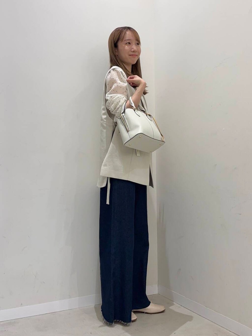 ホワイト系のバレエシューズ、ホワイト系のハンドバッグ、ホワイト系のTシャツ/カットソーを着用したレディースの春コーディネートの2枚目の写真