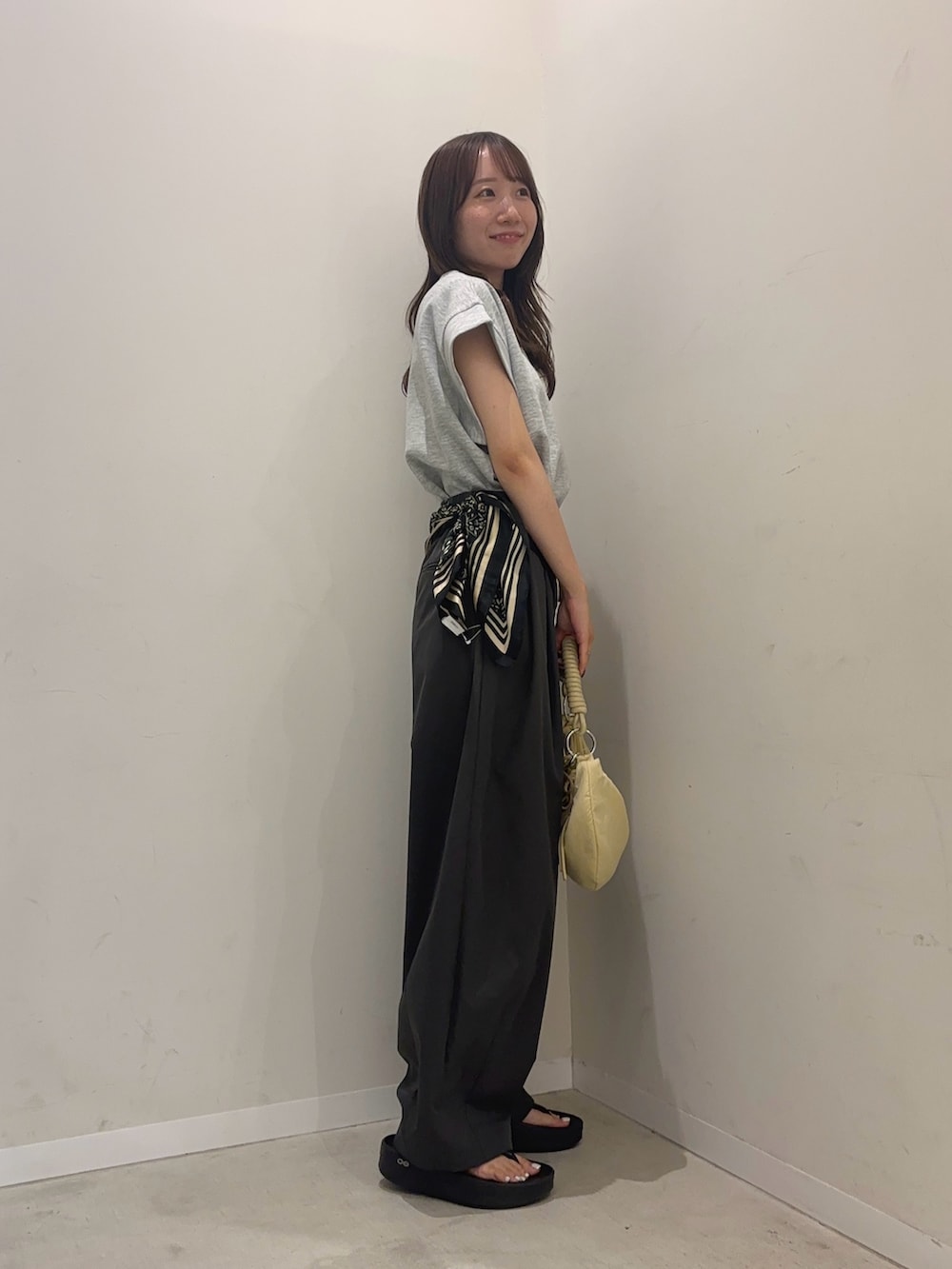 グレー系のTシャツ/カットソー、グレー系のその他パンツ、ベージュ系のハンドバッグを着用したレディースの夏コーディネートの2枚目の写真