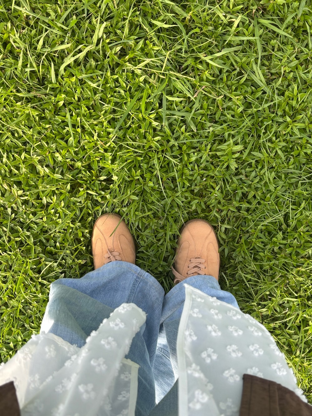 ブラウン系のシャツ/ブラウス、ブルー系のデニムパンツ、ベージュ系のスニーカーを着用したレディースの秋コーディネートの4枚目の写真