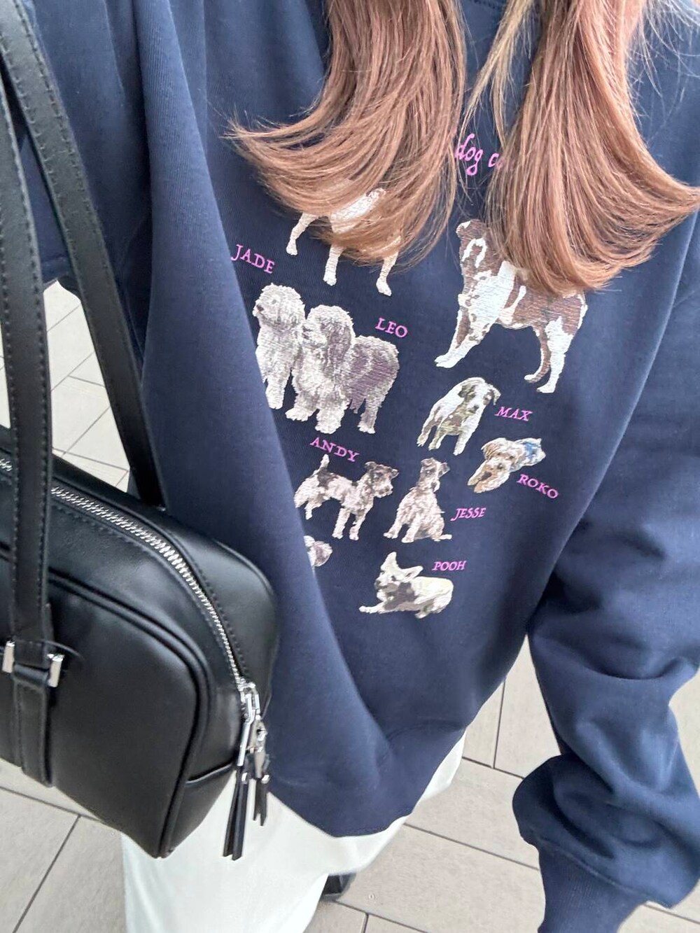 ブラック系のボストンバッグ、ブラック系のスニーカー、ブルー系のスウェットを着用したレディースの冬コーディネートの4枚目の写真