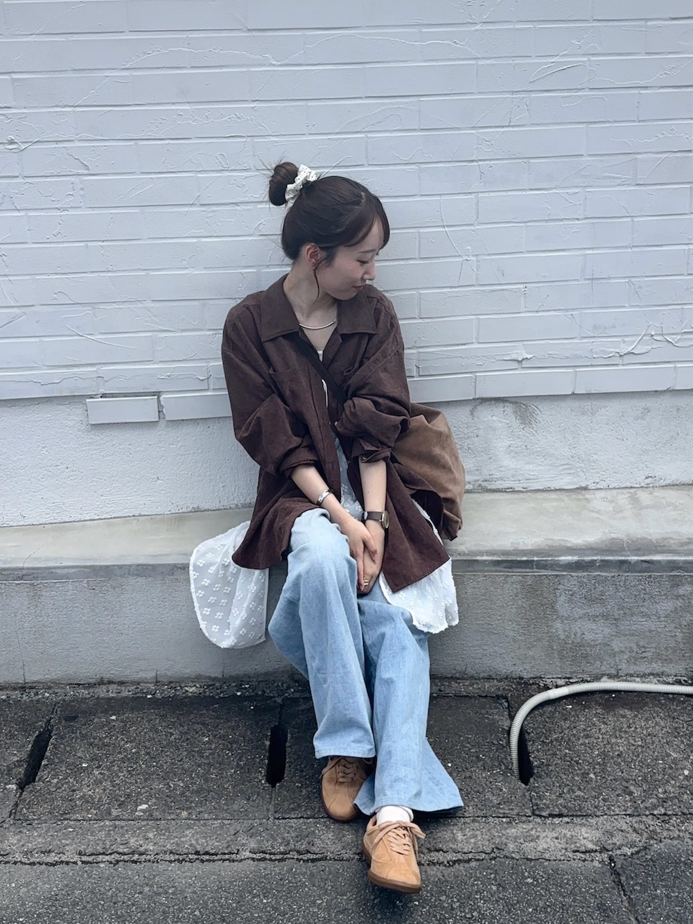 ブラウン系のシャツ/ブラウス、ブルー系のデニムパンツ、ベージュ系のスニーカーを着用したレディースの秋コーディネートの3枚目の写真