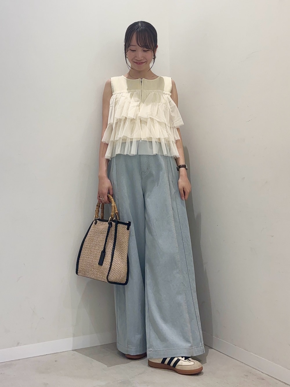 ホワイト系のニット/セーター、ブルー系のデニムパンツ、ブラック系のショルダーバッグを着用したレディースの春コーディネートの2枚目の写真