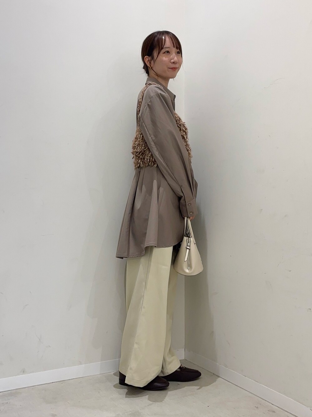 ブラウン系のシャツ/ブラウス、イエロー系のニット/セーター、ベージュ系のその他パンツを着用したレディースの秋コーディネートの3枚目の写真