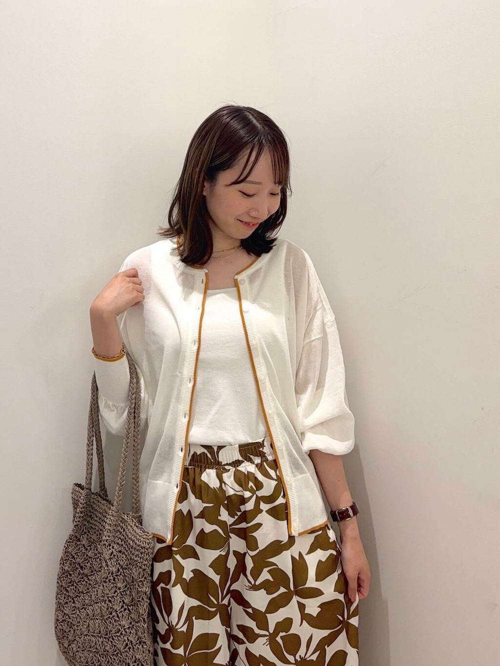 ブラック系のサンダル、グレー系のトートバッグ、ホワイト系のタンクトップを着用したレディースの夏コーディネートの3枚目の写真