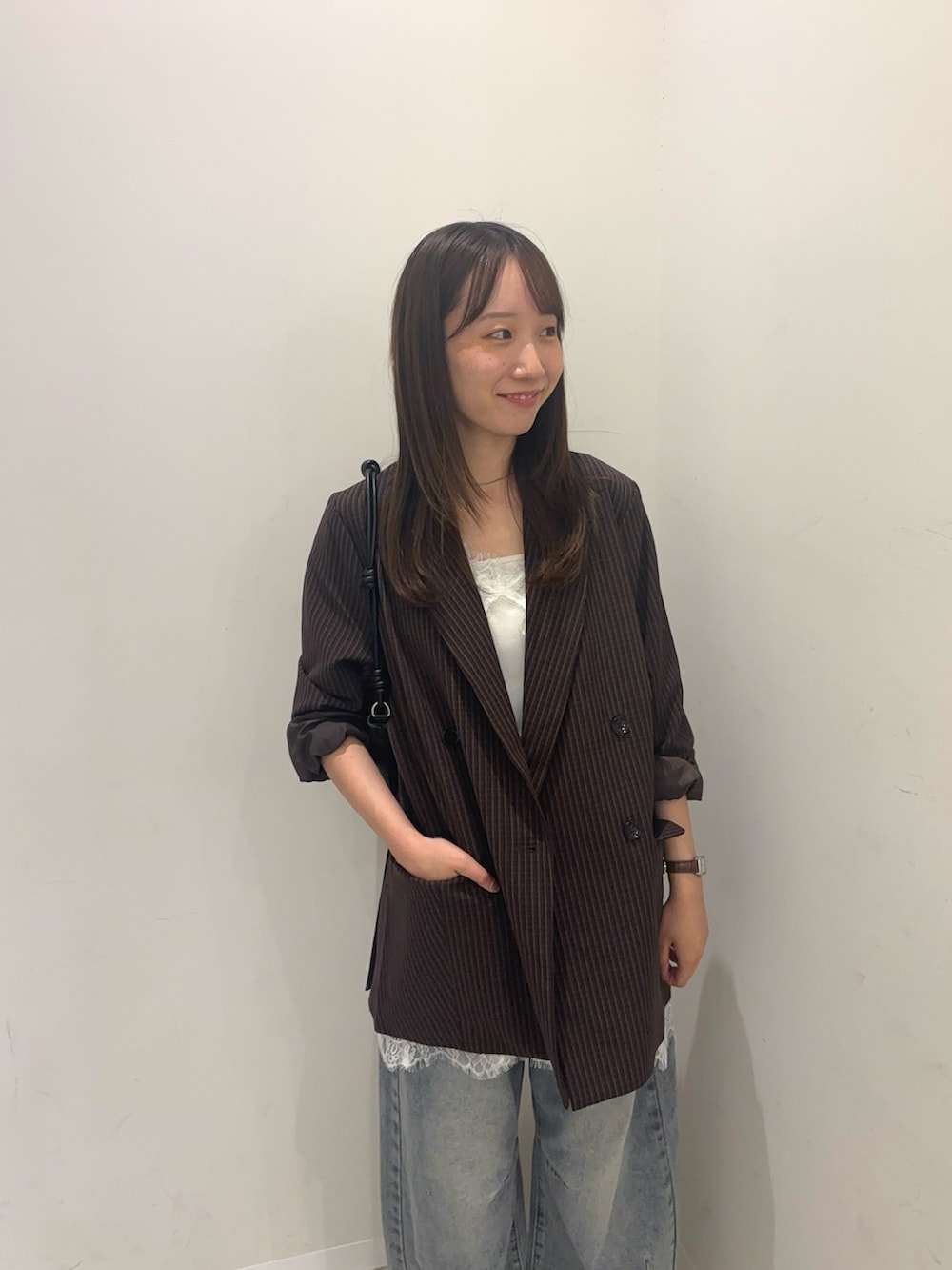 ブラウン系のその他アウター、ホワイト系のキャミソール、ブルー系のデニムパンツを着用したレディースの秋コーディネートの3枚目の写真