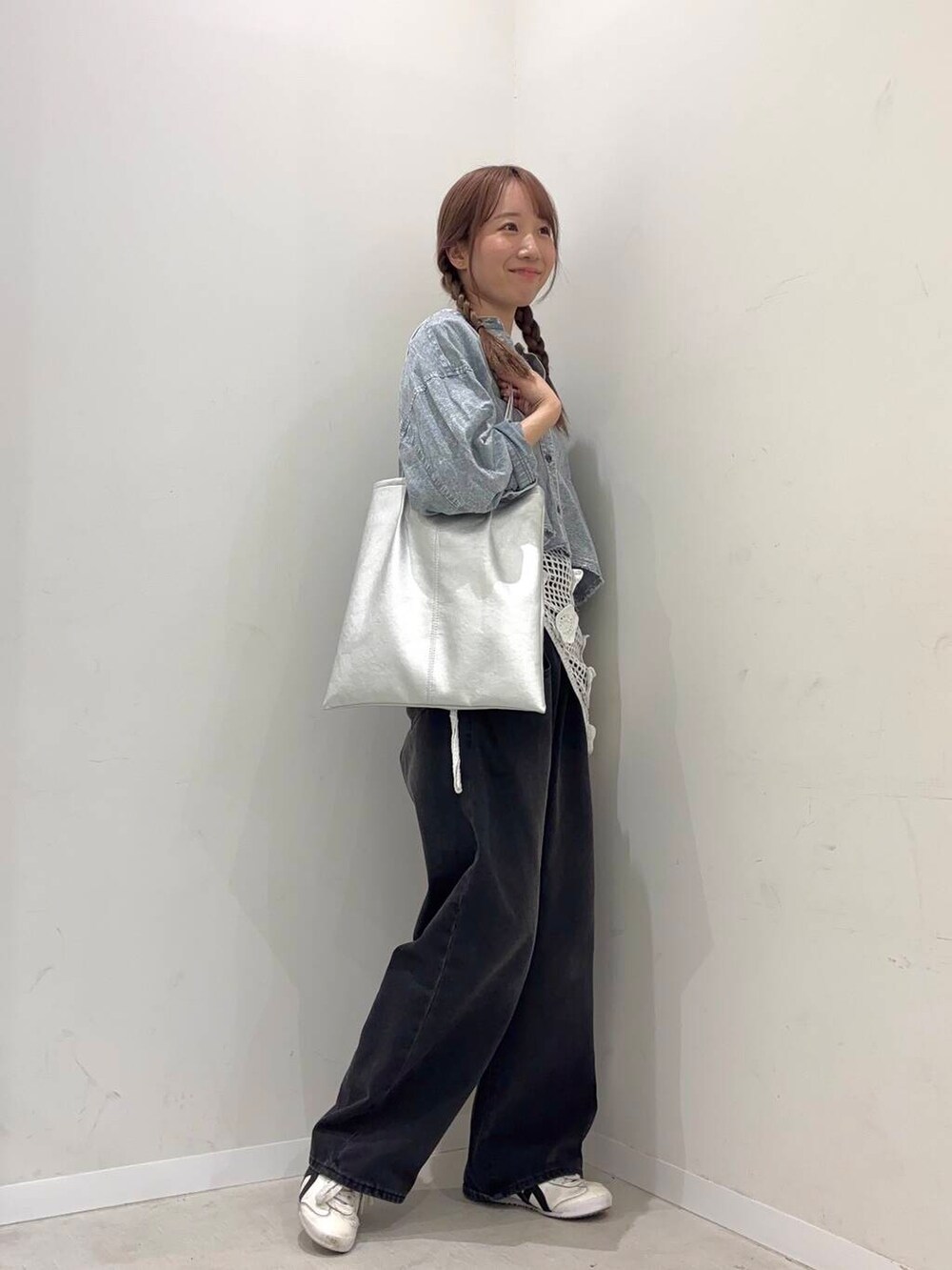 ブラック系のデニムパンツ、グレー系のシャツ/ブラウス、シルバー系のトートバッグを着用したレディースの冬コーディネートの2枚目の写真