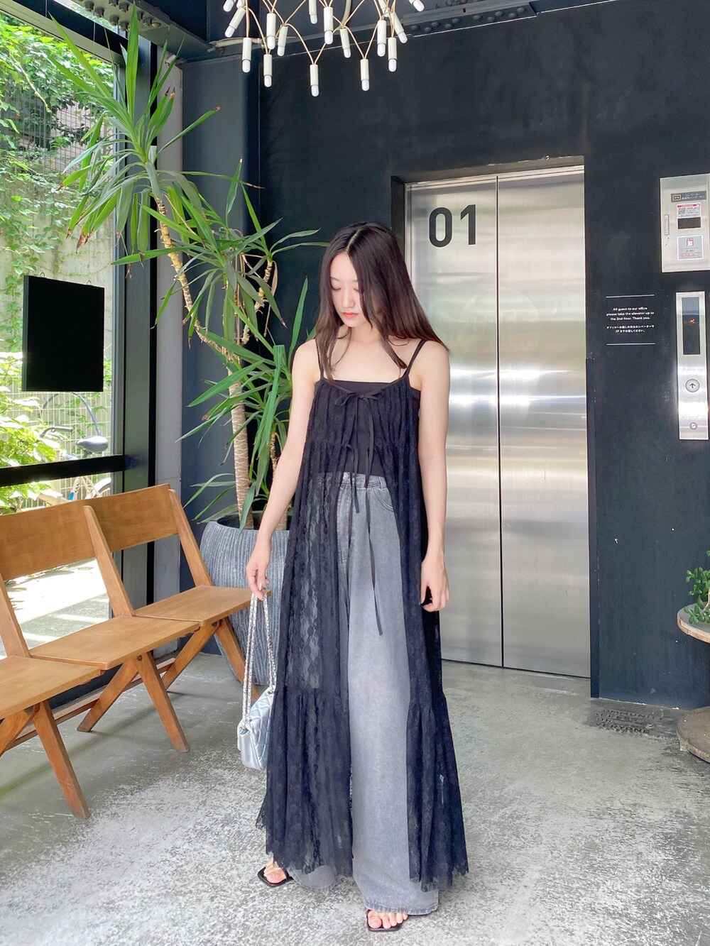 グレー系のデニムパンツ、ブラック系のワンピースを着用したレディースの夏コーディネートの2枚目の写真