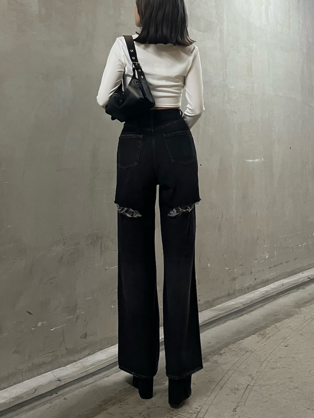 ホワイト系のTシャツ/カットソー、ブラック系のハンドバッグ、ブラック系のデニムパンツを着用したレディースの秋コーディネートの3枚目の写真