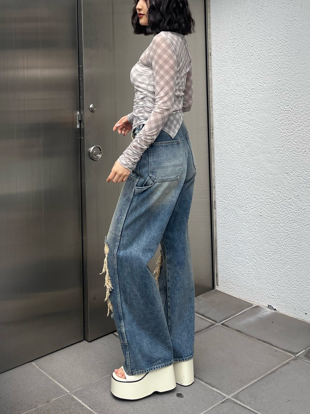 ホワイト系のサンダル、ベージュ系のTシャツ/カットソー、ブルー系のデニムパンツを着用したレディースの春コーディネートの2枚目の写真