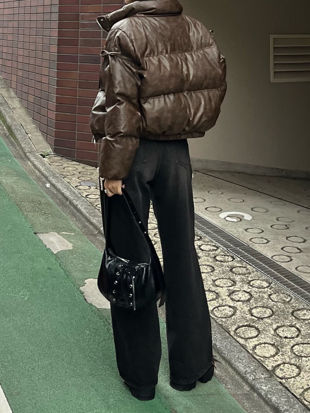 ブラック系のニット/セーター、ブラック系のデニムパンツ、ブラック系のショルダーバッグを着用したレディースの秋コーディネートの2枚目の写真