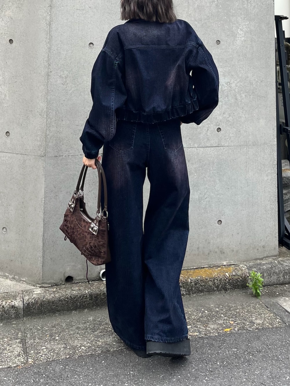 ブルー系のブルゾン、ホワイト系のTシャツ/カットソー、ブラウン系のショルダーバッグを着用したレディースの夏コーディネートの3枚目の写真
