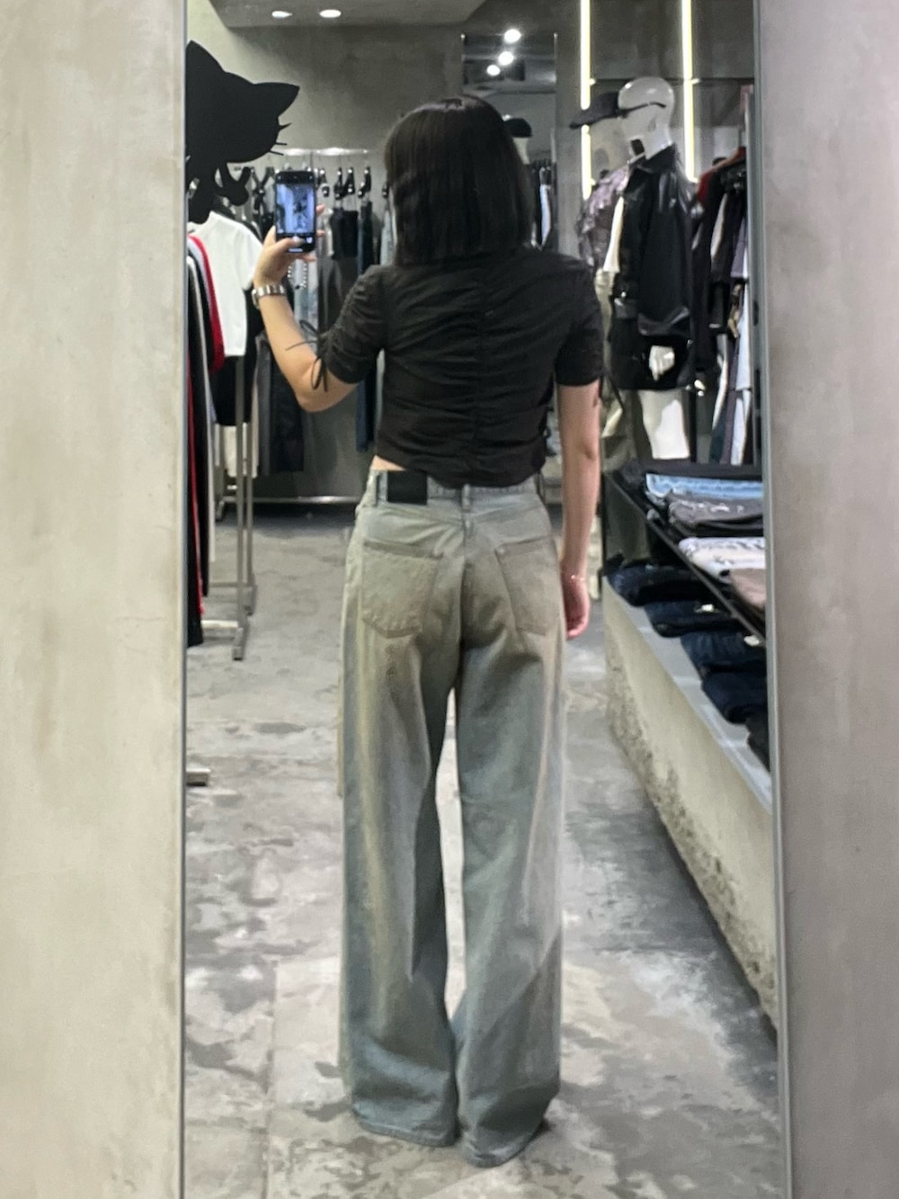 ブラック系のパンプス、ブルー系のデニムパンツ、ブラック系のシャツ/ブラウスを着用したレディースの春コーディネートの3枚目の写真