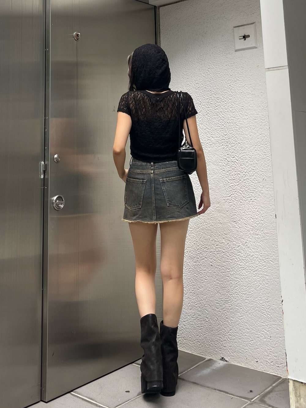 ブラック系のTシャツ/カットソー、ブルー系のスカート、ブラック系のサンダルを着用したレディースの夏コーディネートの2枚目の写真